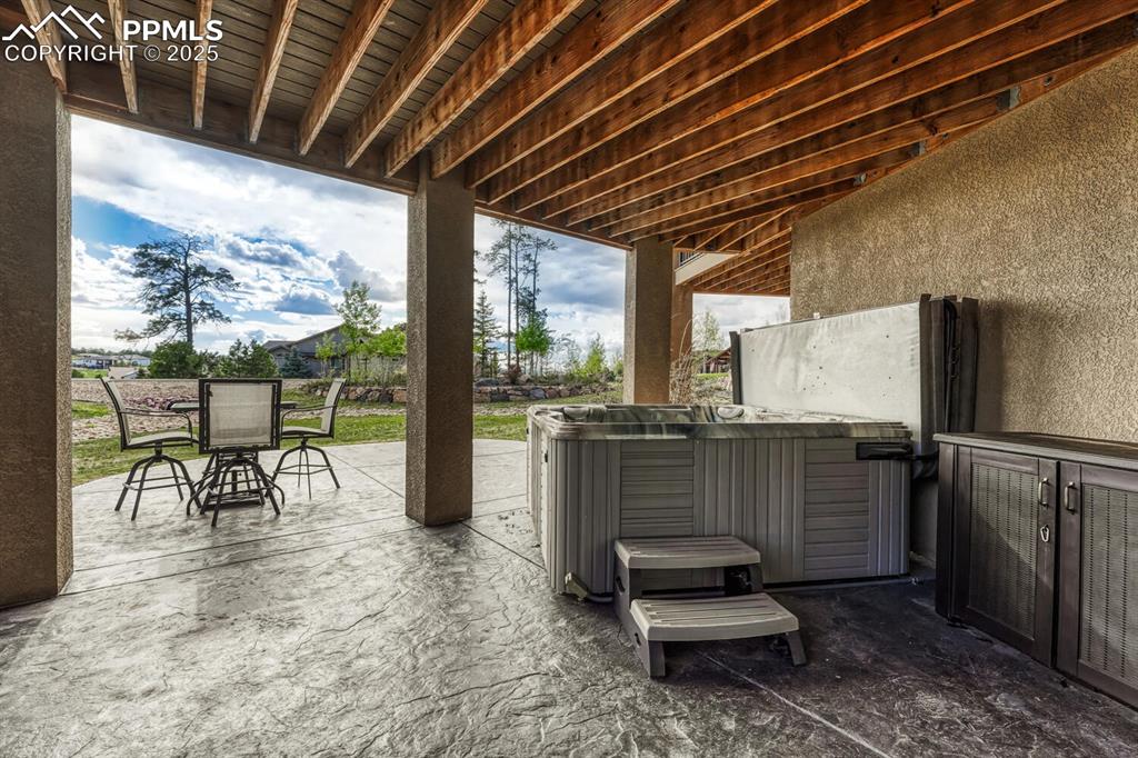 Image 41 of 50: View of patio / terrace with outdoor dining area and a hot tub