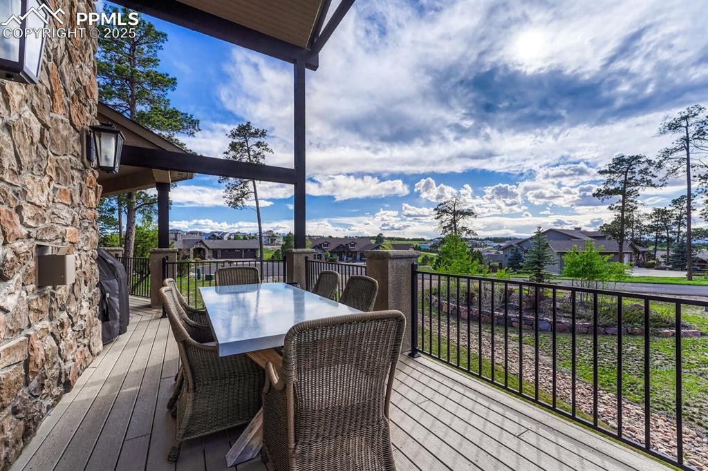 Image 44 of 50: Wooden terrace with outdoor dining area and a residential view
