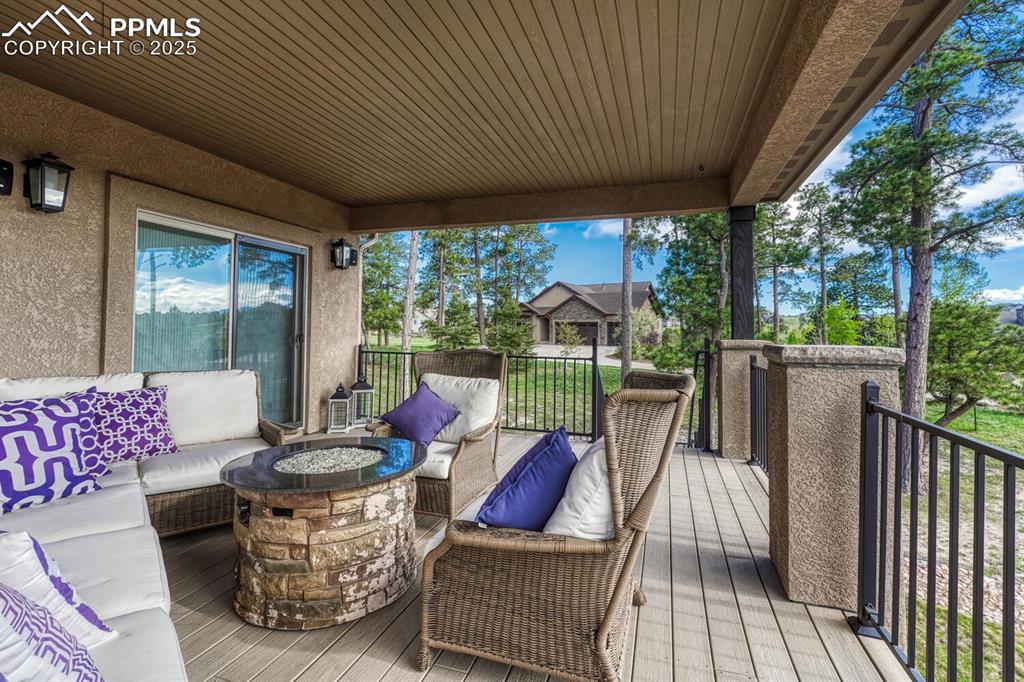 Image 46 of 50: Wooden deck with an outdoor living space with a fire pit