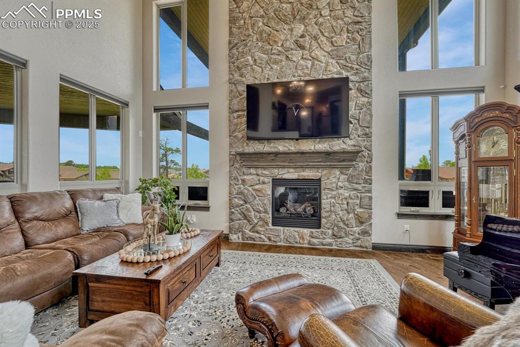Image 5 of 50: Living room with a high ceiling, healthy amount of natural light, wood fini