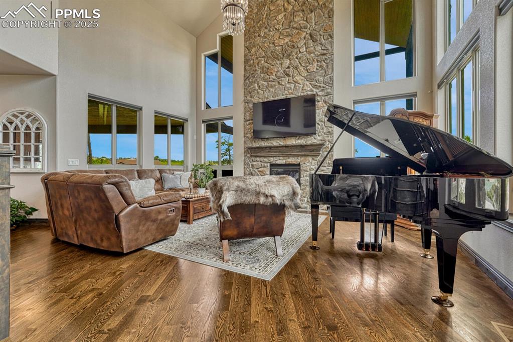 Image 7 of 50: Living area featuring high vaulted ceiling, plenty of natural light, wood f