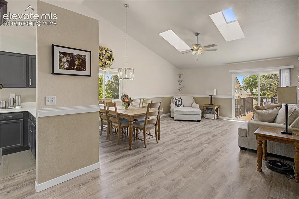 Image 6 of 40: Open dining and living with skylights