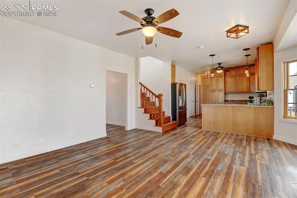 Image 12 of 45: Unfurnished living room with wood-type flooring and ceiling fan