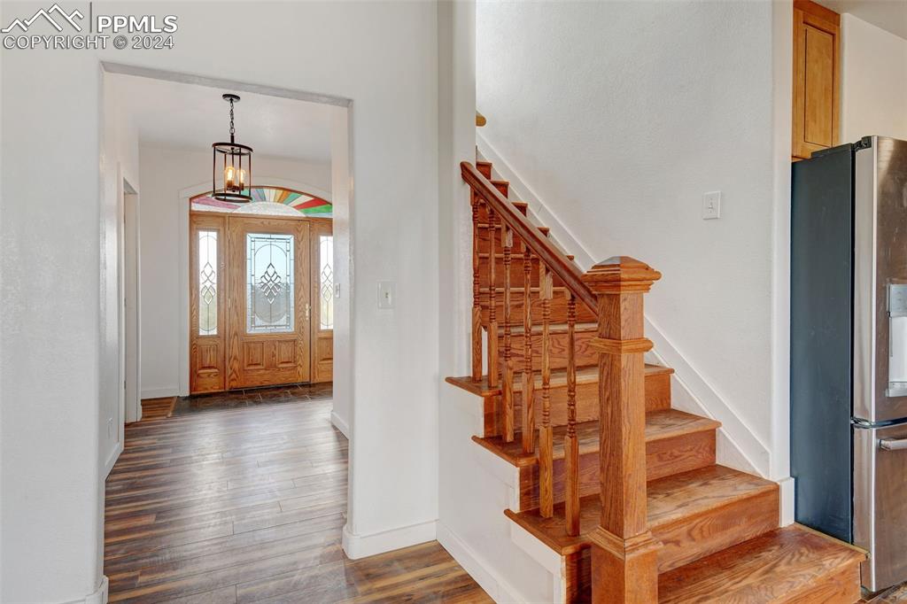 Image 4 of 45: Foyer featuring dark hardwood / wood-style floors and a chandelier