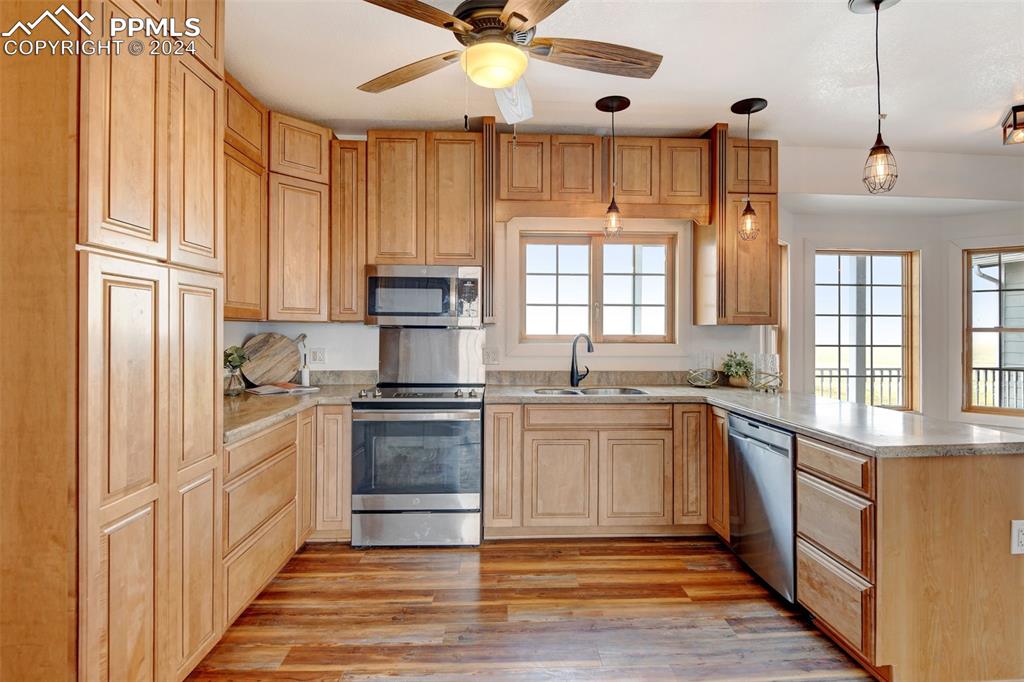 Image 5 of 45: Kitchen featuring ceiling fan, stainless steel appliances, pendant lighting