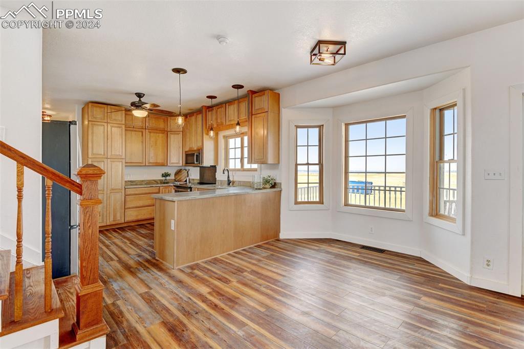 Image 8 of 45: Kitchen featuring kitchen peninsula, ceiling fan, hanging light fixtures, l