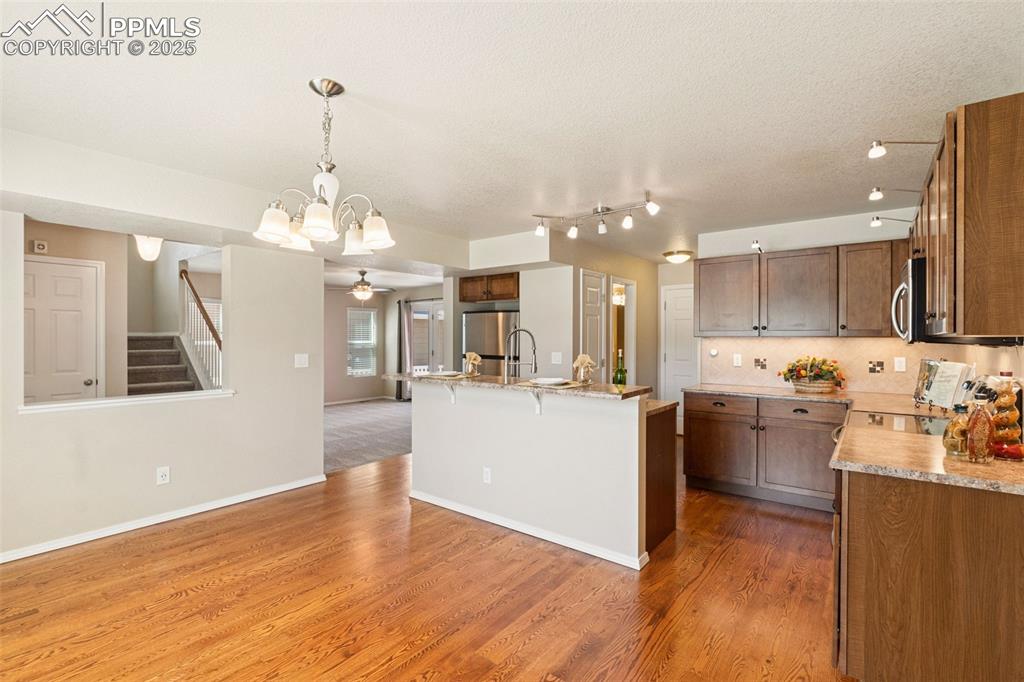 Image 10 of 30: Kitchen featuring light wood-style flooring, appliances with stainless stee