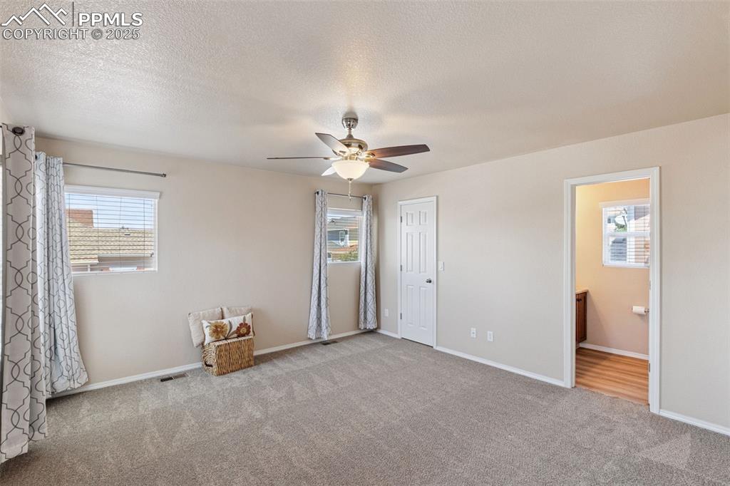 Image 19 of 30: Unfurnished bedroom with carpet, ensuite bathroom, a textured ceiling, and 
