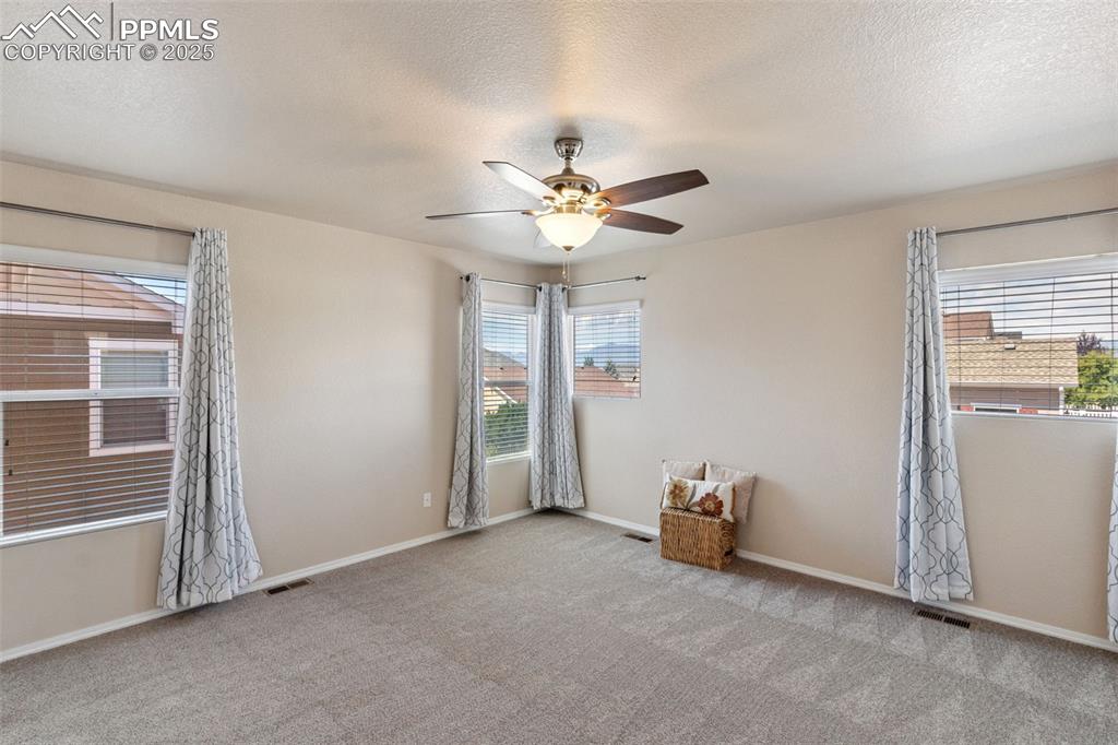 Image 20 of 30: Carpeted spare room featuring a ceiling fan and a textured ceiling