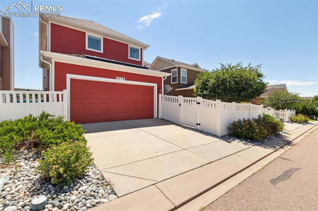 Image 29 of 30: View of front of home featuring a garage and driveway