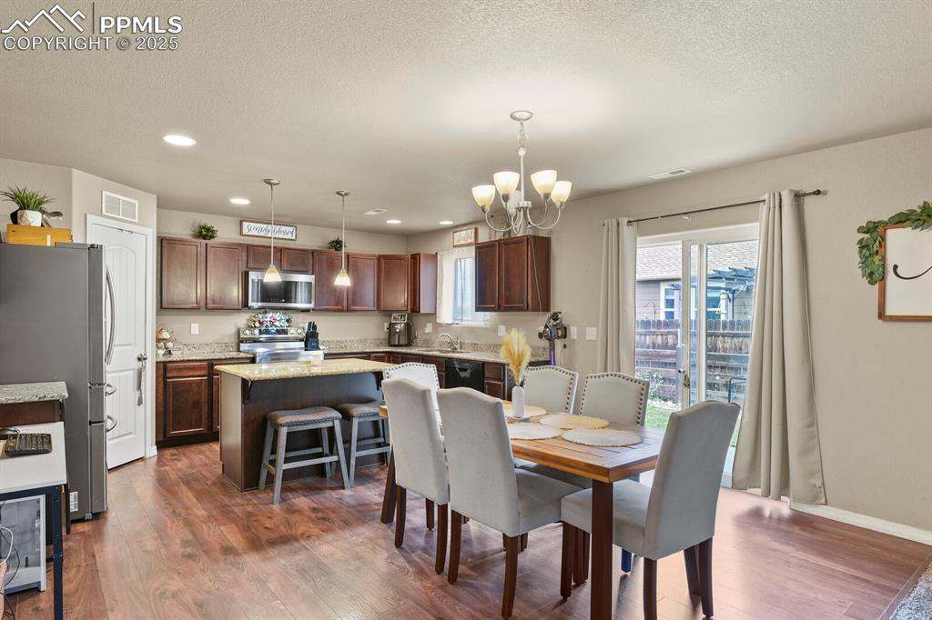 Image 12 of 30: Dining space with a chandelier, recessed lighting, dark wood-style flooring