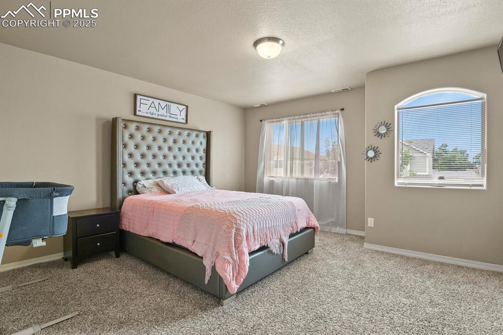 Image 16 of 30: Bedroom with carpet and a textured ceiling