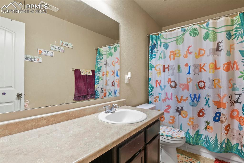 Image 17 of 30: Bathroom with vanity and a shower with shower curtain