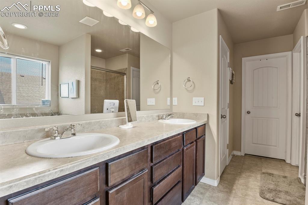 Image 20 of 30: Bathroom with double vanity and a shower stall