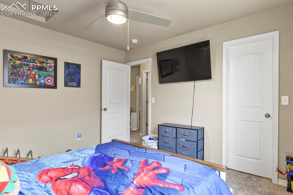 Image 26 of 30: Bedroom with carpet flooring and a ceiling fan