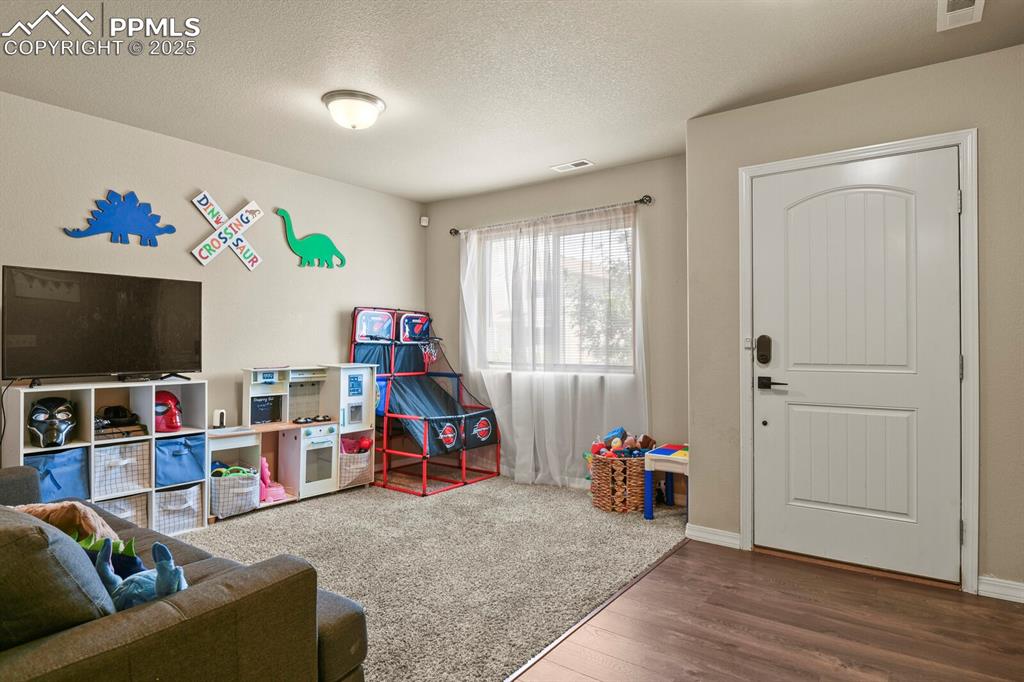 Image 3 of 30: Playroom with wood finished floors and a textured ceiling