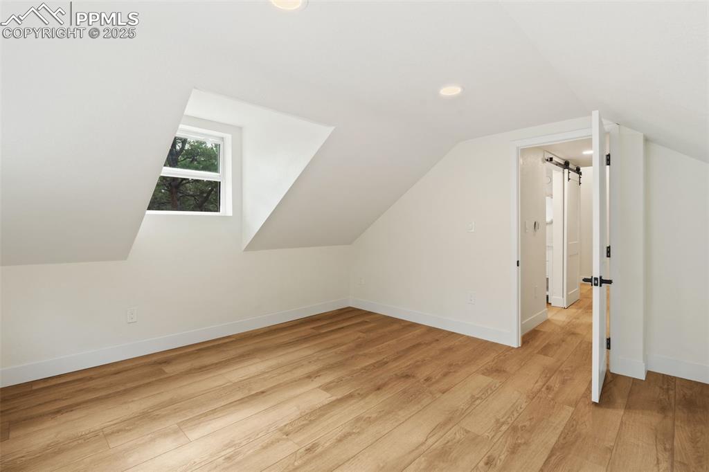 Image 26 of 43: Bonus room with light wood-style flooring, recessed lighting, vaulted ceili