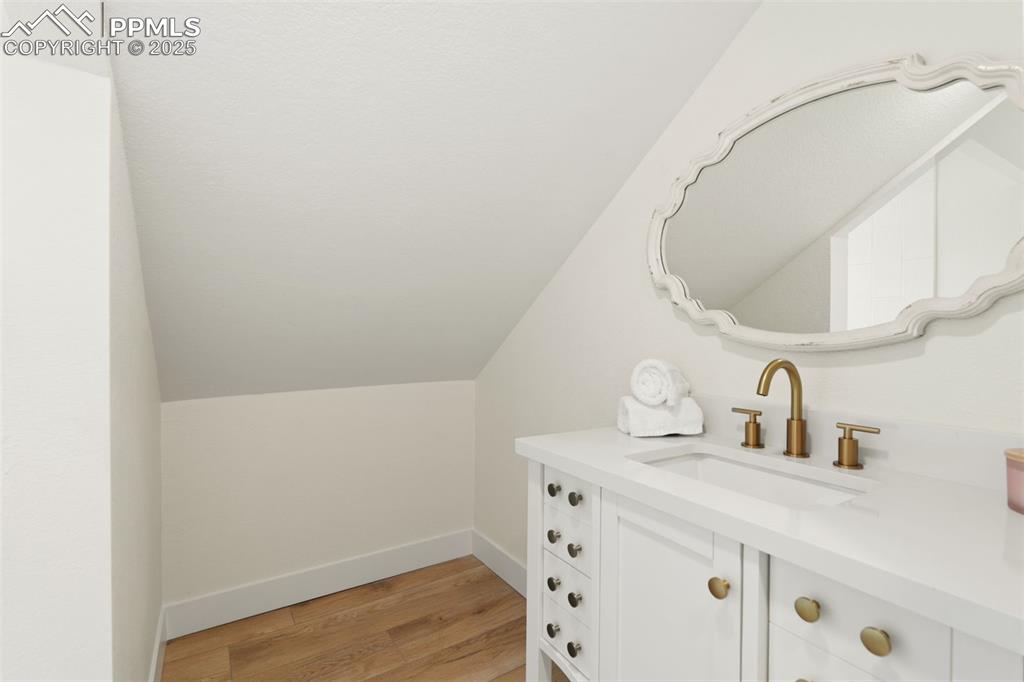 Image 28 of 43: Bathroom featuring vanity, light wood-style floors, and vaulted ceiling