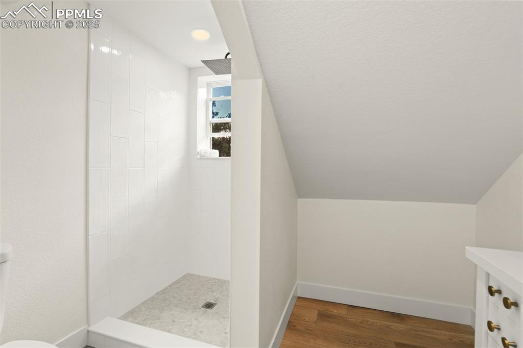 Image 29 of 43: Full bathroom featuring walk in shower, dark wood finished floors, vanity, 