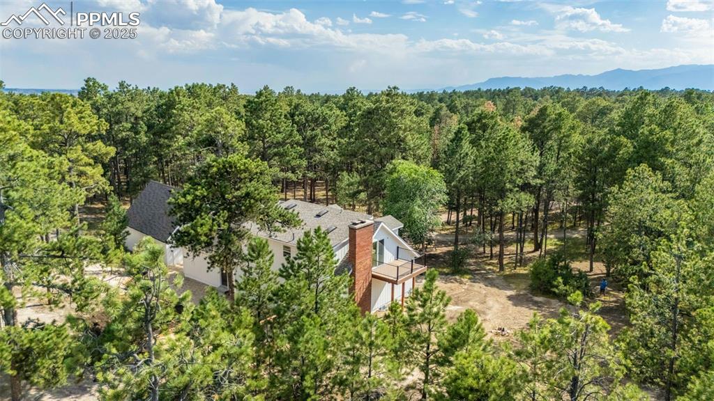 Image 3 of 43: Aerial view of property and surrounding area with a forest