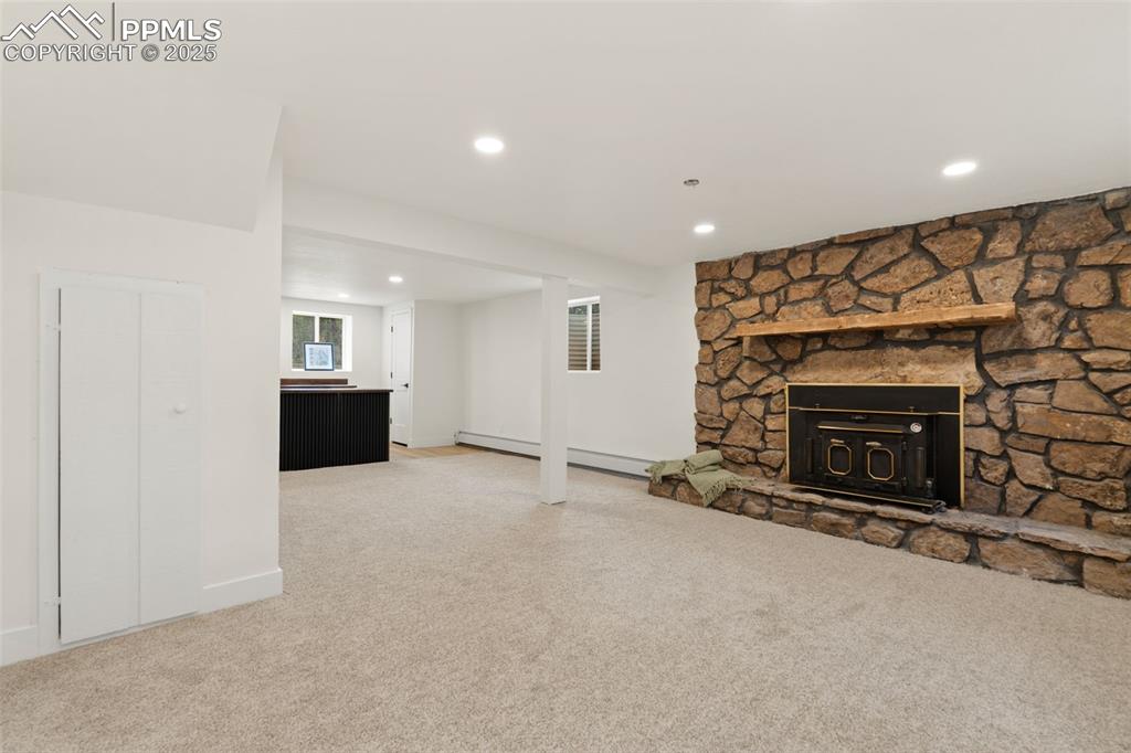 Image 31 of 43: Unfurnished living room featuring recessed lighting, light carpet, and a fi