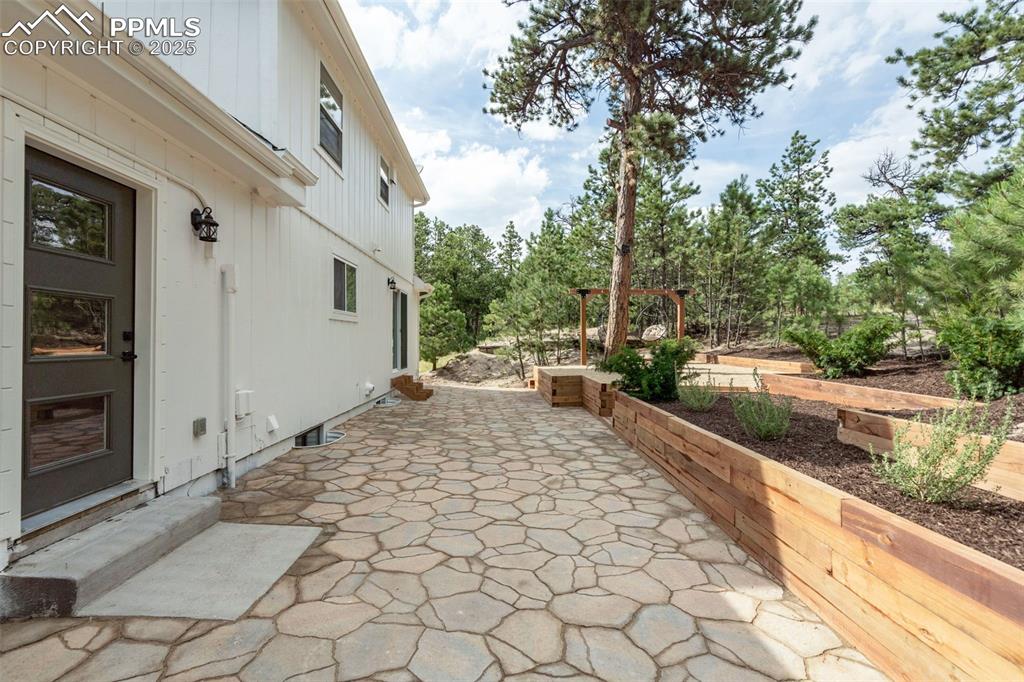 Image 36 of 43: View of patio with view of wooded area