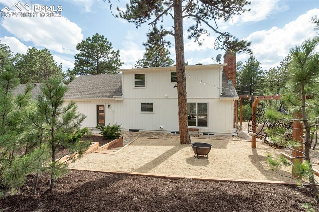 Image 37 of 43: Back of property featuring a patio, an outdoor fire pit, roof with shingles