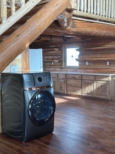 Image 20 of 28: Clothes washing area with laundry area, log walls, washer / clothes dryer,