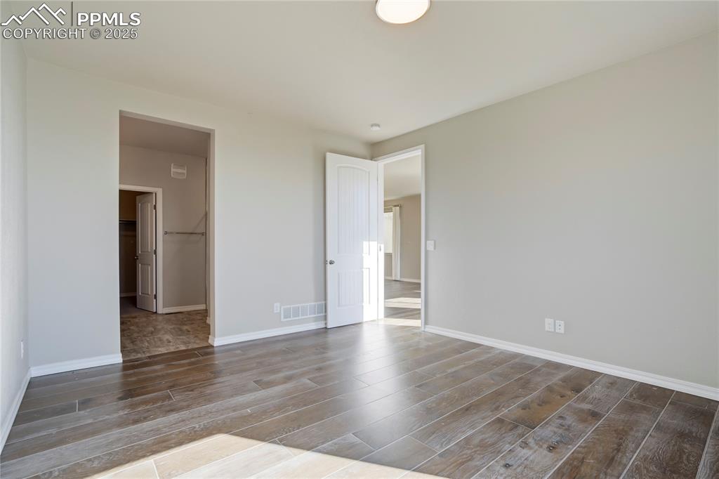 Image 15 of 44: Unfurnished bedroom featuring a spacious closet and wood finished floors