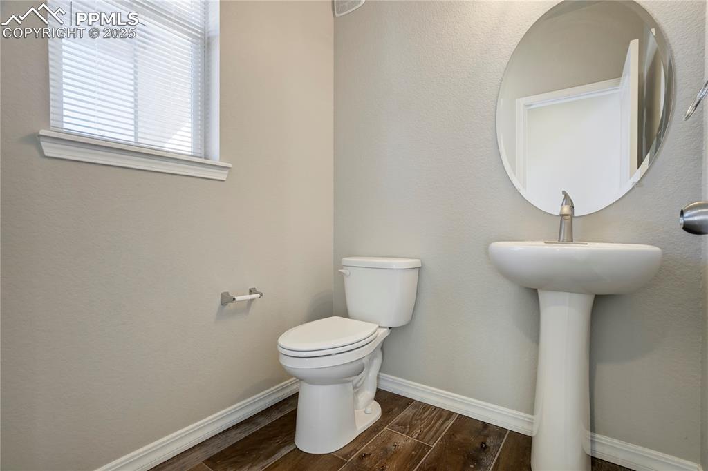 Image 17 of 44: Bathroom with wood finish floors and a textured wall