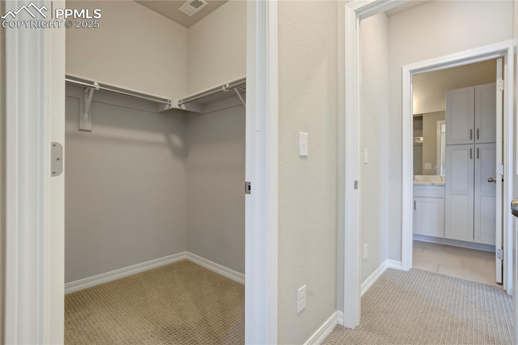Image 31 of 44: Walk in closet featuring light colored carpet