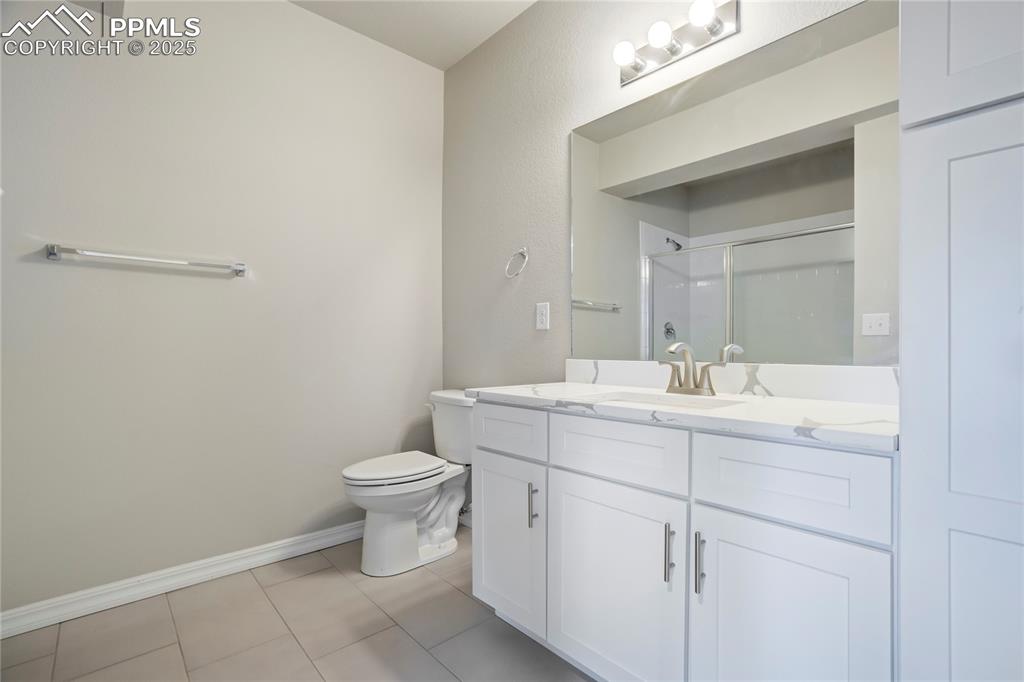 Image 32 of 44: Full bath featuring a shower stall, vanity, and light tile patterned floors