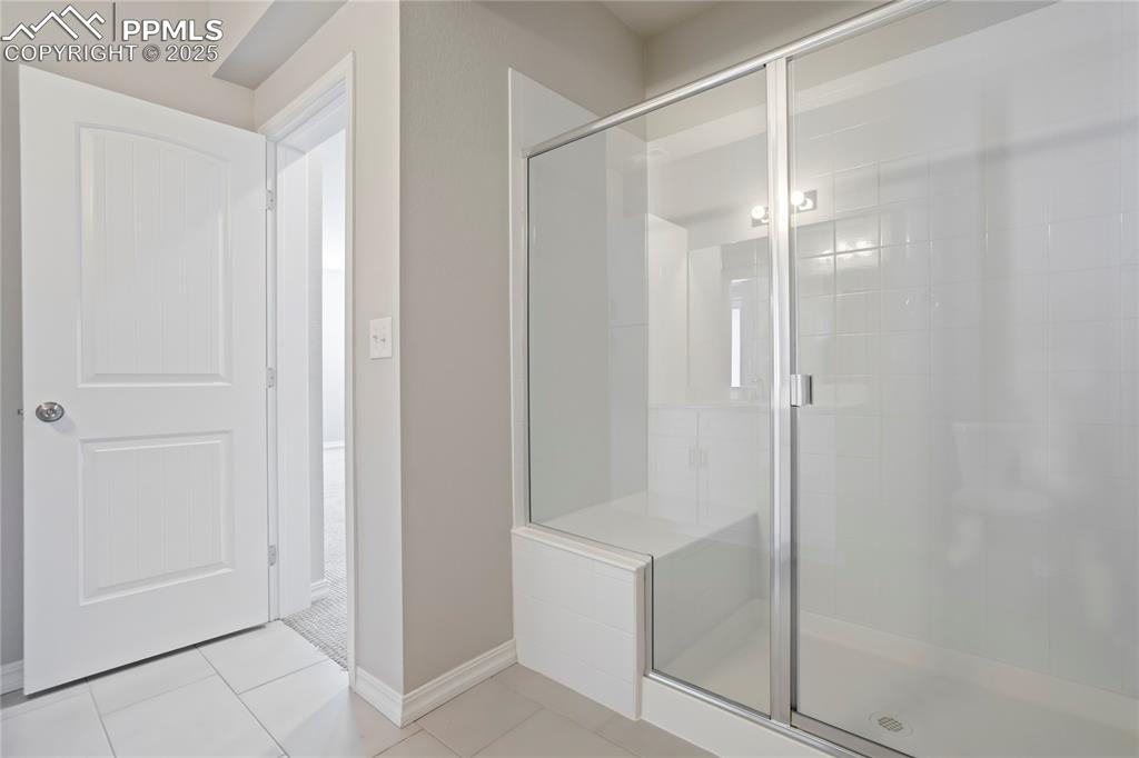 Image 33 of 44: Full bathroom with a stall shower and light tile patterned flooring
