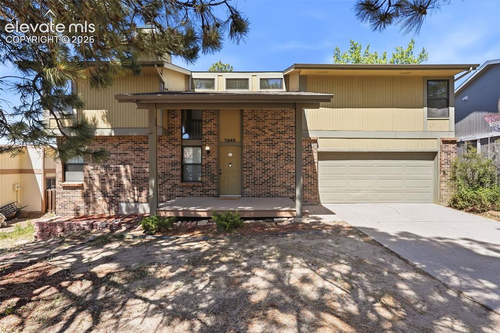 Image 2 of 50: Split-level residence featuring a brick facade and horizontal siding