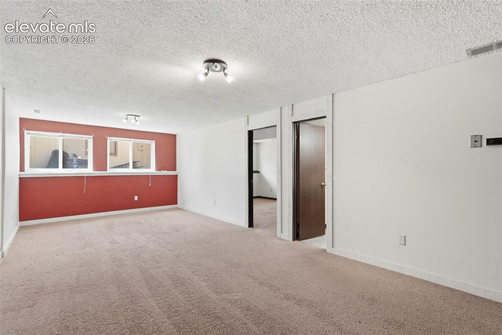 Image 22 of 50: Carpeted room featuring a white ceiling, recessed windows with white trim, 