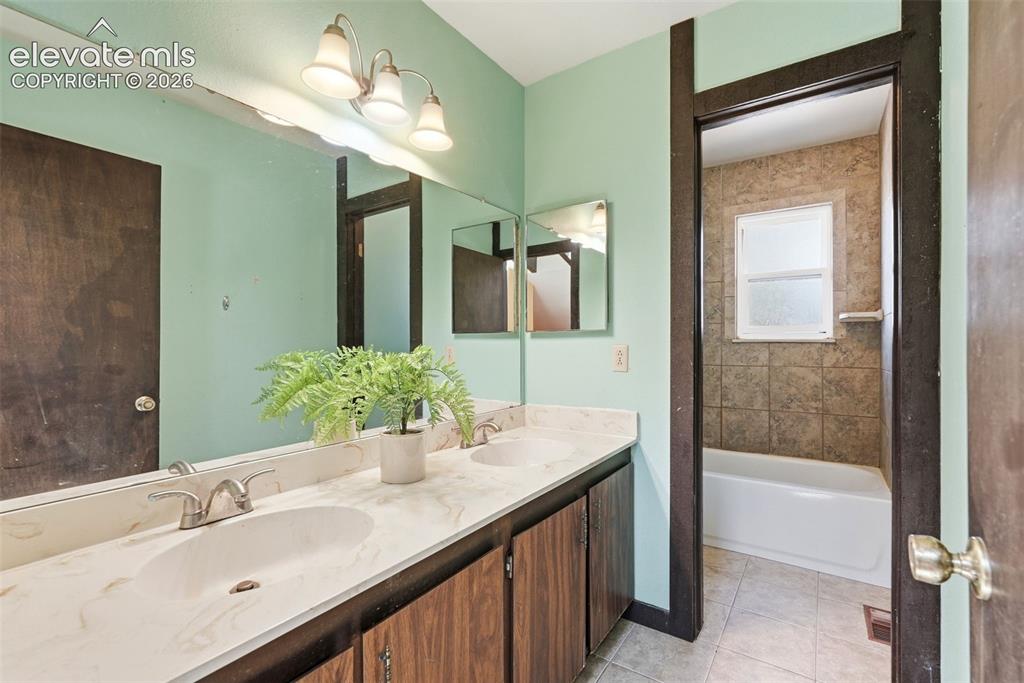 Image 33 of 50: Bathroom featuring a dual vanity with a light-colored countertop and underm