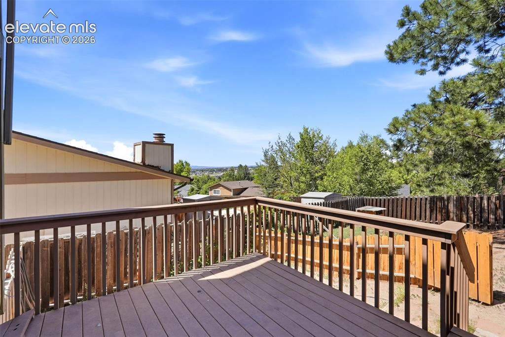 Image 43 of 50: Expansive outdoor wood-finish deck with full railing and balusters