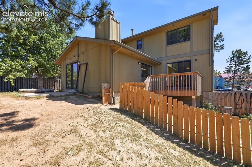 Image 45 of 50: Multi-level exterior with horizontal siding and a prominent chimney feature