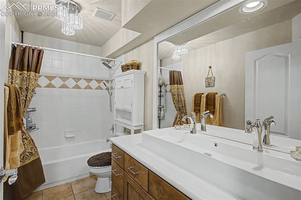 Image 29 of 46: Full lower level bathroom with dual fixture sink