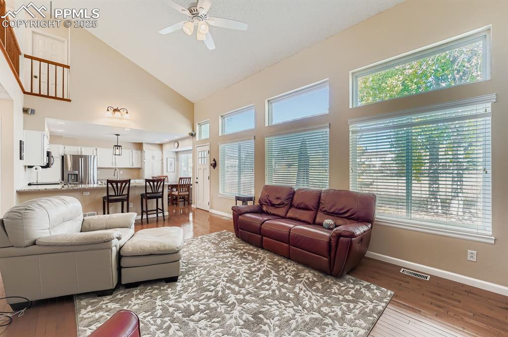Image 10 of 32: Living area with high vaulted ceiling, light wood-style flooring, and ceili