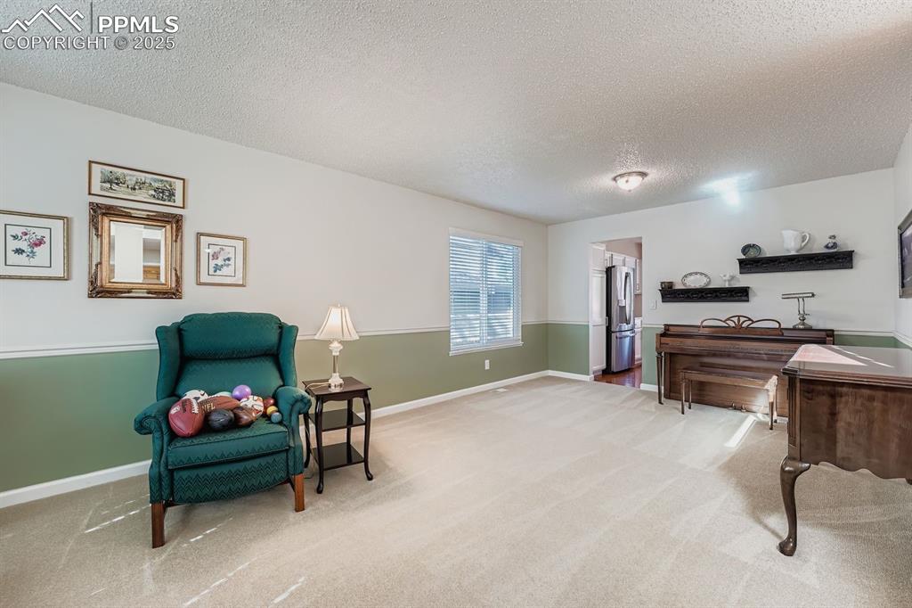 Image 12 of 32: Sitting room featuring a textured ceiling and light carpet