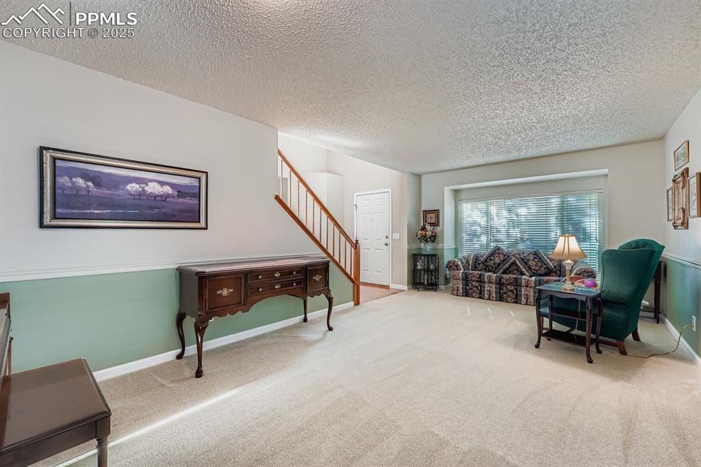 Image 13 of 32: Sitting room featuring carpet, a textured ceiling, and stairway