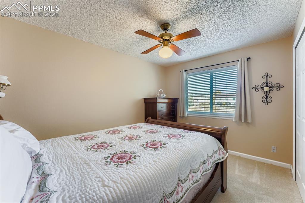 Image 23 of 32: Bedroom featuring carpet floors, ceiling fan, a textured ceiling, and a clo