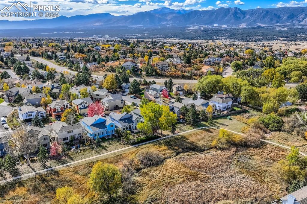 Image 29 of 32: Aerial view of residential area featuring a mountainous background