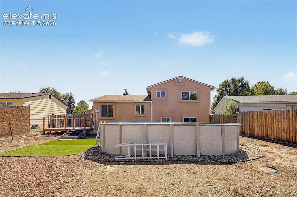 Image 23 of 37: Expansive backyard featuring a deck with stairs, an above-ground pool (will