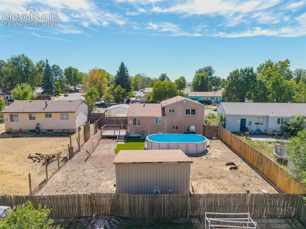Image 28 of 37: Aerial view of expansive backyard featuring a privacy fence, above-ground p