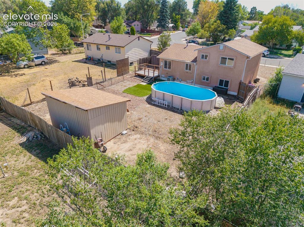 Image 29 of 37: Backyard featuring an above-ground pool, a detached storage shed, fencing a