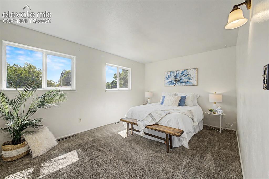 Image 8 of 37: Plush gray carpeting and more natural light fill the oversized primary bedr
