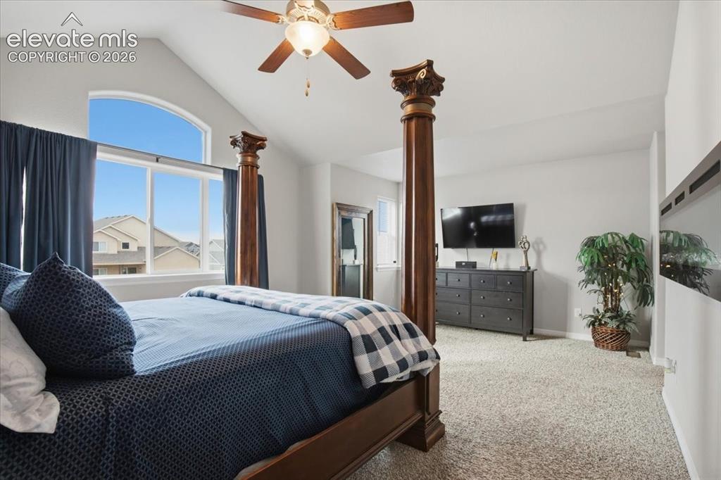 Image 14 of 31: Vaulted ceiling, arched window, ceiling fan, and light gray walls