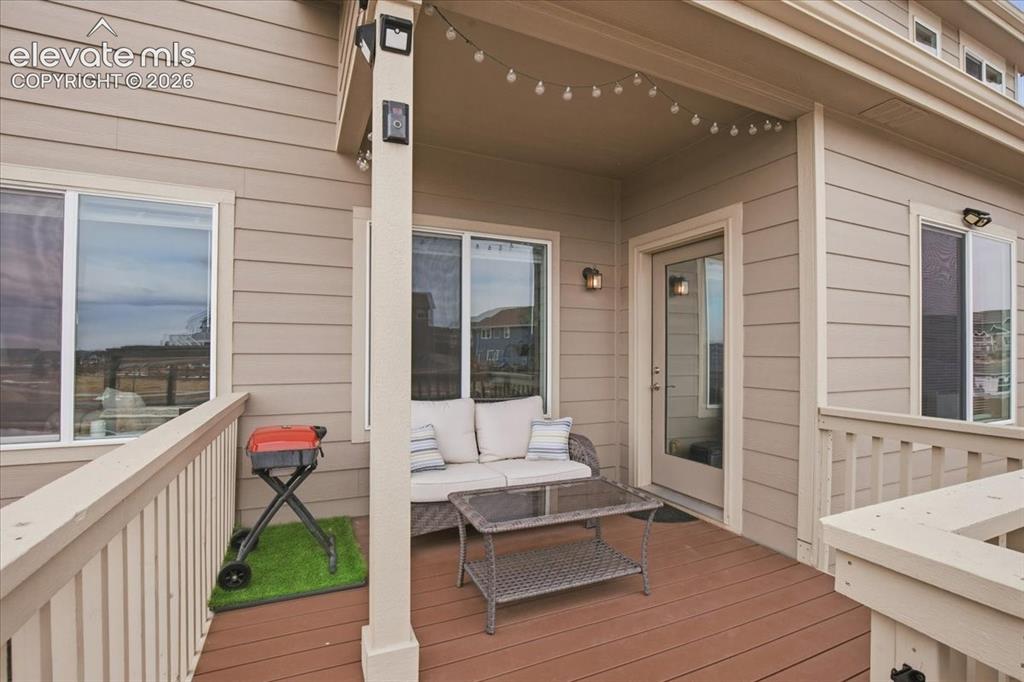 Image 28 of 31: Covered outdoor deck with wood-finish flooring, featuring exterior siding a